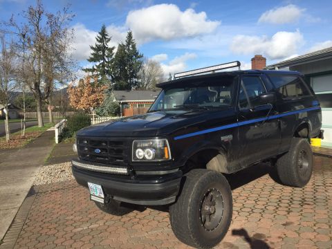 1992 Ford Bronco - This 1992 Ford Bronco features a distinctive blue stripe and aftermarket lighting, including a light bar above the windshield.