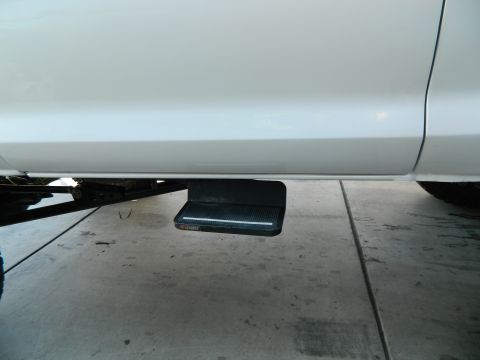 1979 Ford Bronco - A black running board step is visible on the side of a white vehicle.