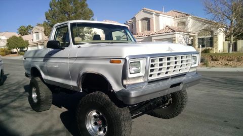 1979 Ford Bronco - Lifted 1978 Ford F-150 pickup truck with custom grille and large off-road tires.