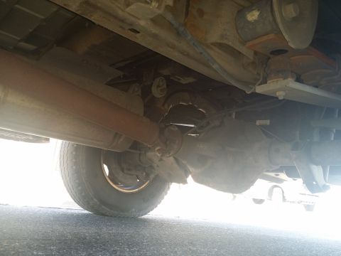2001 Ford Excursion - The underside of a vehicle is visible, including the rear axle and exhaust system.