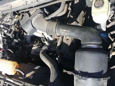 2001 Ford Excursion - Close-up of a Ford Triton V10 engine bay, showing the air intake system and various hoses.
