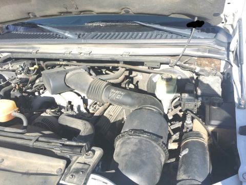 2001 Ford Excursion - The engine compartment of a vehicle is shown with various hoses and components.