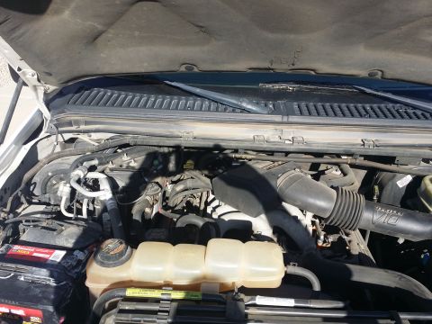 2001 Ford Excursion - The engine bay of a 2001 Ford Excursion is visible with the hood raised, revealing the V10 engine and associated components.