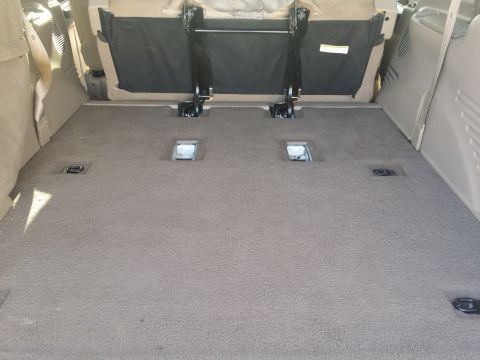 2001 Ford Excursion - The cargo area of an SUV shows folded seats and floor anchors.
