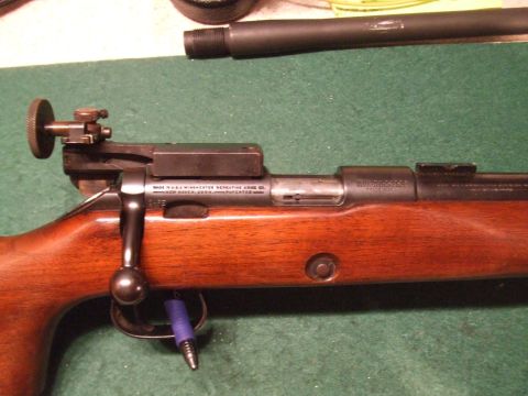1996 Ford Bronco - Close-up view of a rifle's receiver, showing the bolt handle and rear sight assembly.