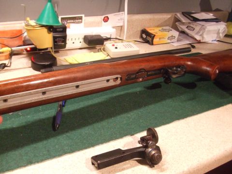1996 Ford Bronco - A rifle is shown disassembled on a green mat, with its wooden stock and various metal components laid out.