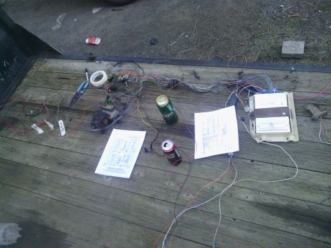 1978 Ford Bronco - A complex vehicle wiring harness is spread out on a trailer deck with diagrams and two open cans of beer.