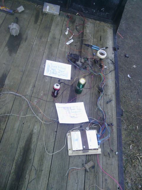 1978 Ford Bronco - Electrical components and wiring are laid out on a wooden deck, possibly for repair or installation.
