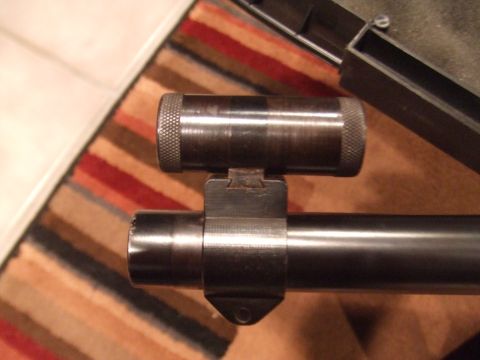 1996 Ford Bronco - Close-up of a rifle scope mount on a barrel, with a striped rug visible.
