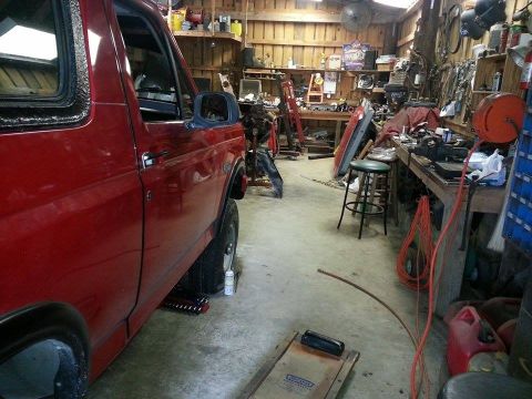 1995 Ford Bronco - Side view of a red 1995 Ford Bronco in a workshop environment.