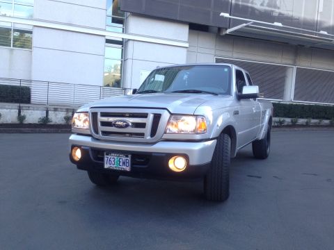2010 Ford Ranger - This silver Ford Ranger pickup truck is viewed from the front, parked on pavement with a building in the background.