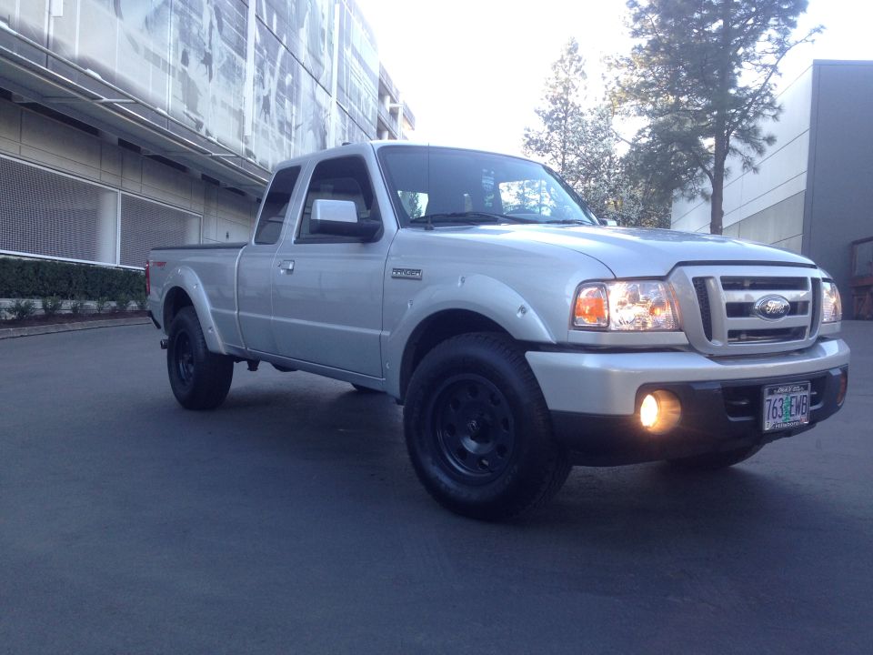 Silver pickup truck with black wheels, front 3/4 view