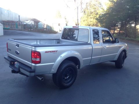 2010 Ford Ranger - Silver pickup truck with 'SPORT 4x4' decal on the rear fender.