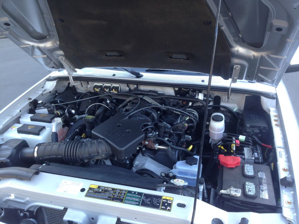 Silver Ford Ranger engine bay with hood open. Visible components include the engine, battery, air intake, and various hoses and wires
