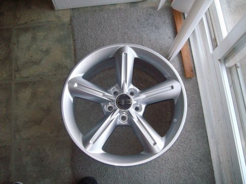 2004 Ford Crown Victoria - A single silver 5-spoke wheel is shown, with a black center cap that has readable text.