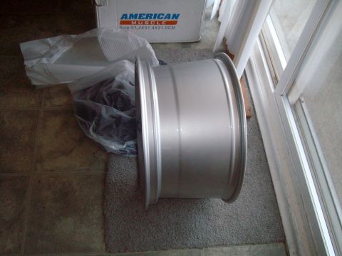 2004 Ford Crown Victoria - An aluminum wheel is shown next to its "American Muscle" branded box, which details its size.