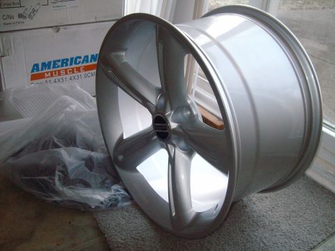 2004 Ford Crown Victoria - A single aftermarket wheel is shown, with boxes from 'AMERICAN MUSCLE' in the background.