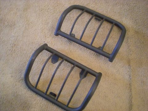 1993 Ford Bronco - Two aftermarket headlight guards are shown lying on a carpeted surface.