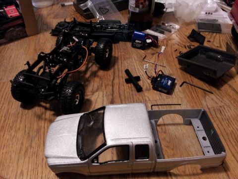 1995 Ford Bronco - RC truck parts are spread out on a table, ready for assembly.