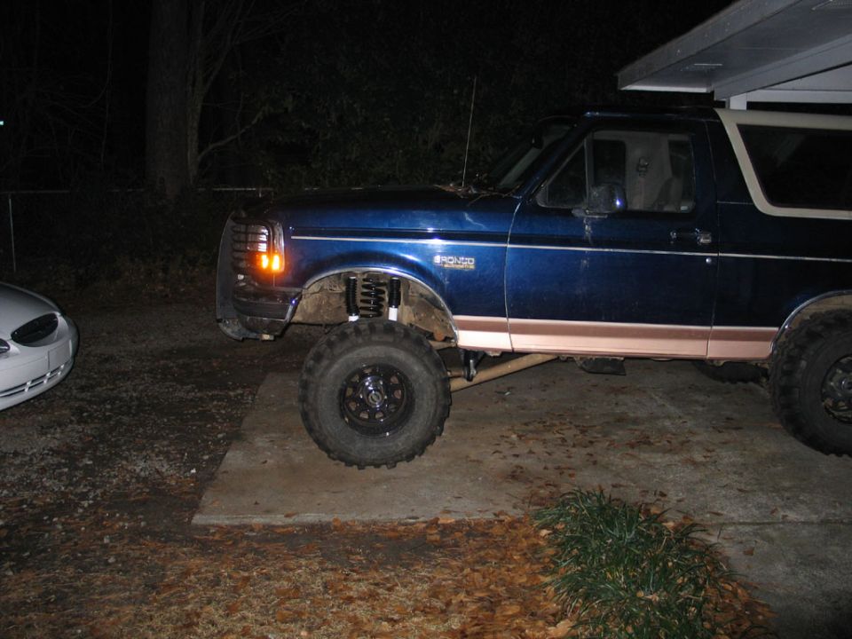 1995 Ford Bronco with lifted suspension and large tires, side view