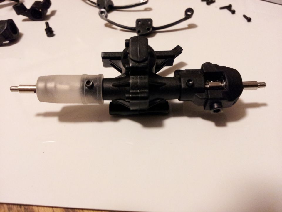 RC car differential assembly with clear plastic cover and metal shafts