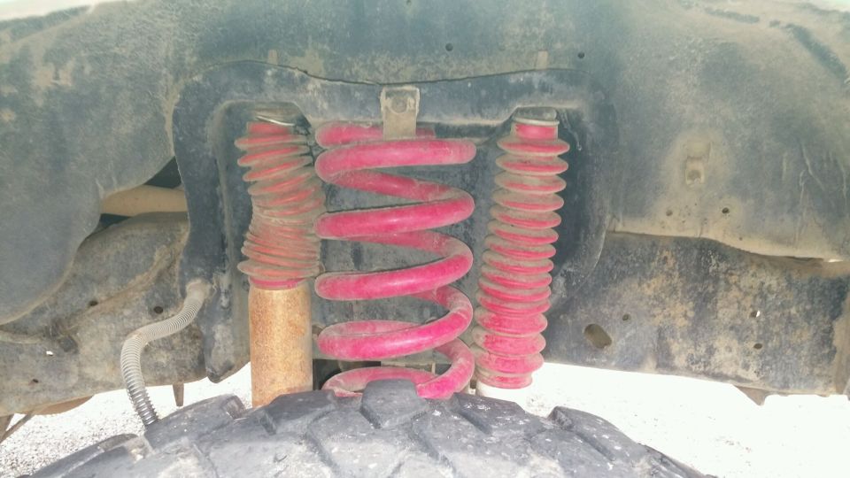 Close-up of red coil springs and shock absorbers with rubber boots