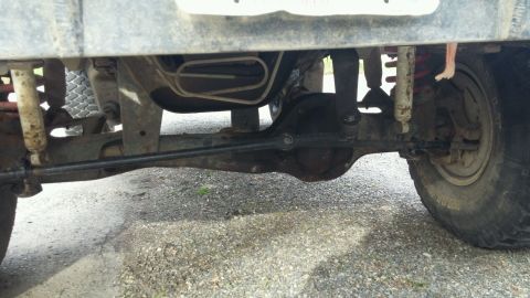 1990 Ford Bronco - The photo shows the rear axle assembly, including the differential, suspension, and shocks of a vehicle.