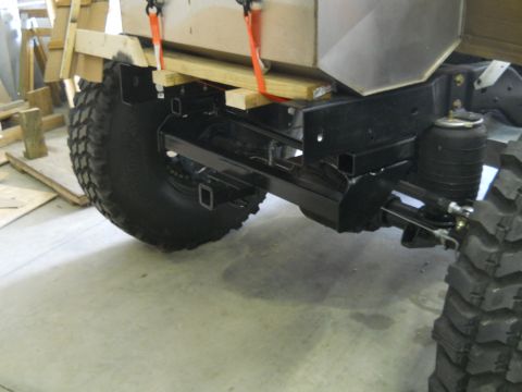 1992 Ford Bronco - The rear chassis of a modified truck is visible, large tires and air suspension components.