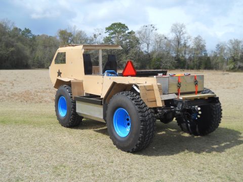 1992 Ford Bronco - This custom-built vehicle features large tires and a unique tan body, seen outdoors.