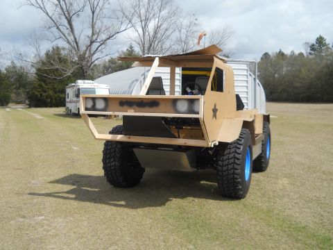 1992 Ford Bronco - A custom-built vehicle with a unique design and large off-road tires is shown outdoors.