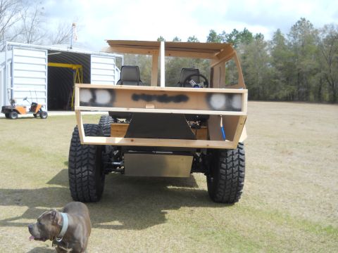 1992 Ford Bronco - A partially constructed vehicle made of wood sits outdoors with a dog in the foreground.