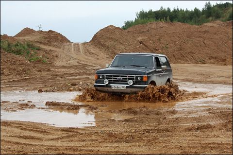 1987 Ford Bronco - A black 1987 Ford Bronco navigates a muddy obstacle course.