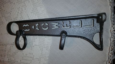 2015 Chevrolet new - A cast iron part with cut-out letters reads "B.C.M.W.J." and has two rings and a hook.