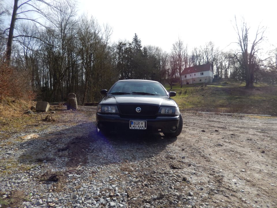 Black 2003 Mercury Marauder parked on a gravel lot with a house in the background