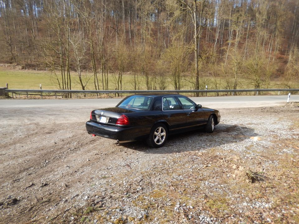 Black 2003 Mercury Marauder parked on gravel shoulder, rear three-quarter view