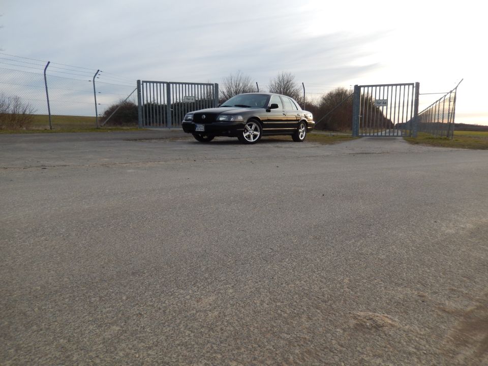 Black 2003 Mercury Marauder parked near metal gates