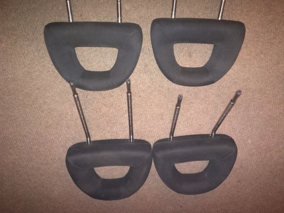 Four black car headrests with metal posts