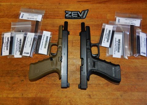 1996 Ford Bronco - Two handguns and various gun parts are displayed on a wooden table, with the ZEV Technologies logo visible.