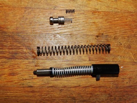 1996 Ford Bronco - Various gun components and springs are arranged on a wooden surface.
