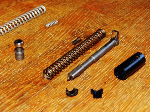 1996 Ford Bronco - Various springs and metal components are arranged on a wooden surface, with a 'Supermotors.net' logo visible.