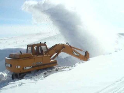1979 Ford Bronco - Excavator clearing snow in a snowy landscape.