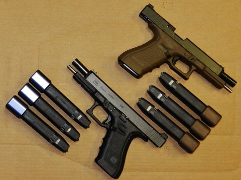1996 Ford Bronco - Two Glock pistols and multiple magazines are arranged on a wooden background.