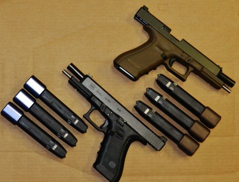 1996 Ford Bronco - Two Glock pistols and their magazines are arranged on a flat surface, with a Supermotors logo in the corner.