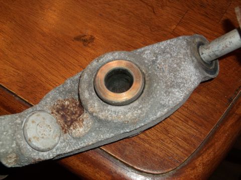 1999 Mercury Grand Marquis - A close-up view of a vehicle's suspension control arm, showing wear and a brass bushing.