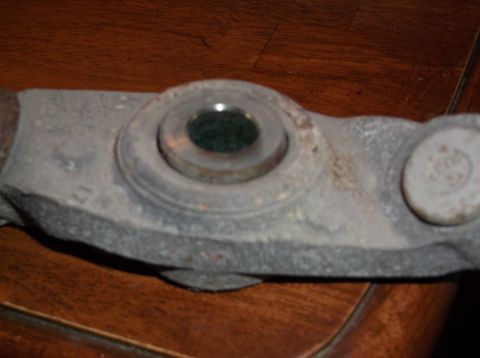 1999 Mercury Grand Marquis - A close-up view of a metal automotive part, likely from the axle assembly, resting on a wooden surface.