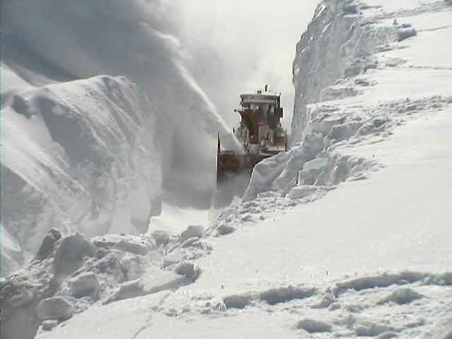 Snow blower clearing a path through deep snowdrifts