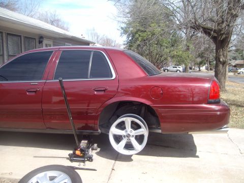2004 Ford Crown Victoria - Changing a flat tire on a 2004 Ford Crown Victoria in the driveway.