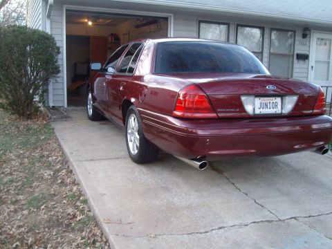 2004 Ford Crown Victoria - This maroon sedan is parked in front of a garage with its rear facing the camera.