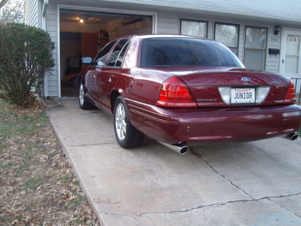Maroon 2004 Ford Crown Victoria parked in driveway, rear view. License plate says JUNIOR