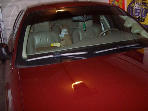 2004 Ford Crown Victoria - The interior of a red sedan is visible through the windshield, with boxes stacked in the rear seat.
